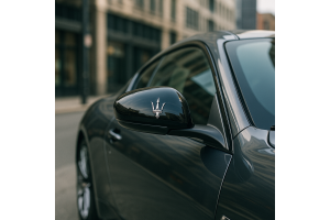Sleek Maserati side mirror reflecting an urban skyline